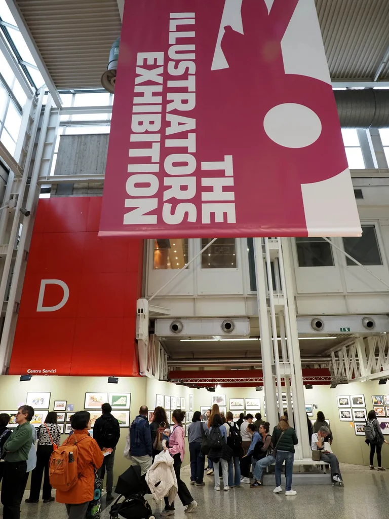 Visitors entering The Illustrators Exhibition beneath a large hanging sign.