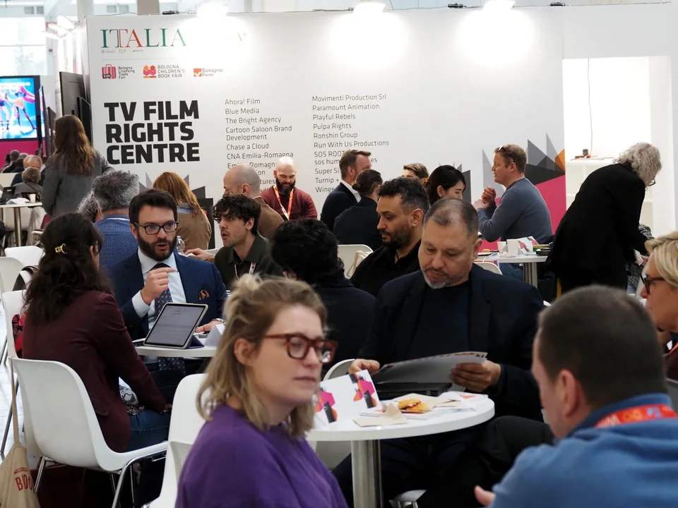 Professionals discussing projects at tables in the TV/Film Rights Centre.